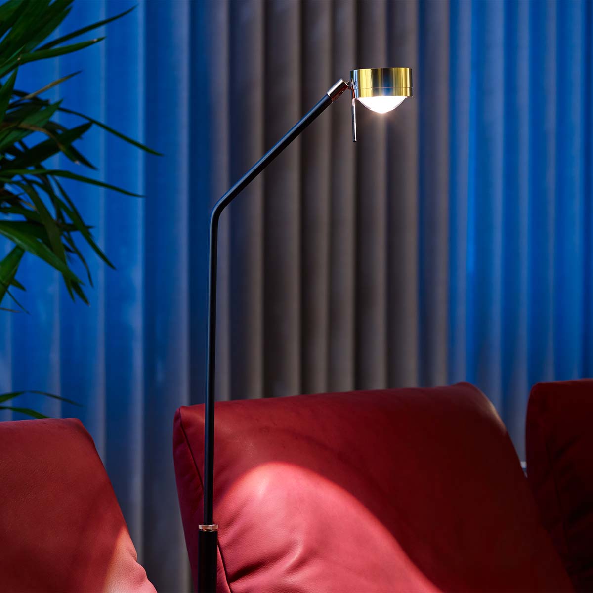 Perfekt für Wohnzimmer oder Leseecke: Licht im Raum Movie X Stehleuchte, H: 95- 155 cm höhenverstellbar, Verchromt aus gebürstetem Messing – gerichtete Beleuchtung Licht im Raum Movie X Schmale Stehleuchte neben einem Stuhl stehend