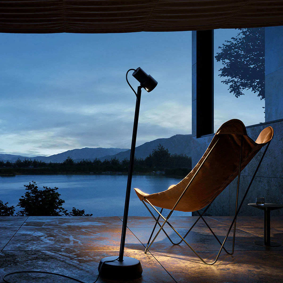 Schmale Pollerleuchte mit connect Stecker auf der Terasse neben einem Stuhl