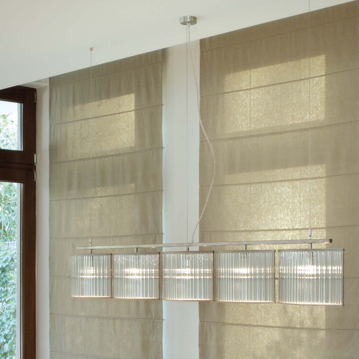 Moderne Pendelleuchte mit fünf geschwungene Glasschirmen an der Decke hängend