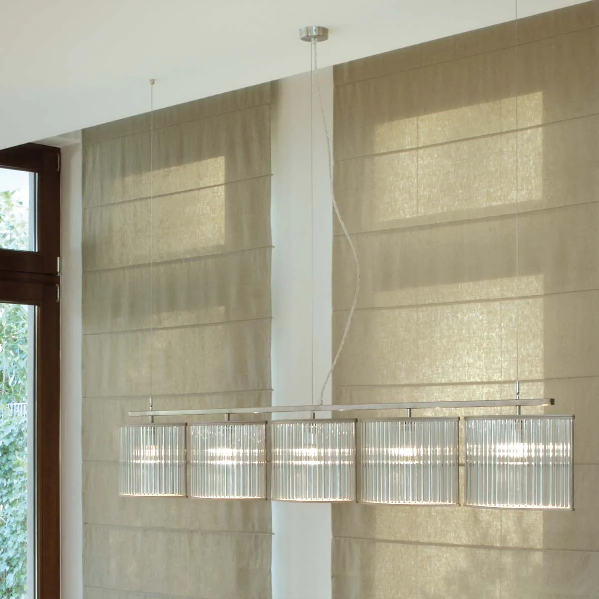 Moderne Pendelleuchte mit fünf geschwungene Glasschirmen an der Decke hängend