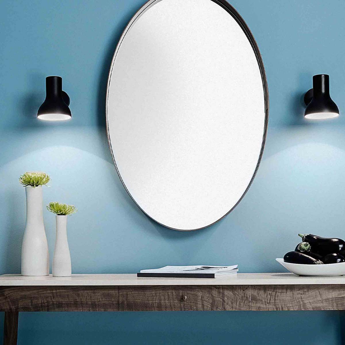 Anglepoise Type 75 Mini Wandleuchte, Ø: 13 cm, H: 15 cm im Wohnambiente: schwarze Mini-Wandleuchten neben rundem Spiegel an hellblauer Wand mit modernem Badezimmer-Ambiente.