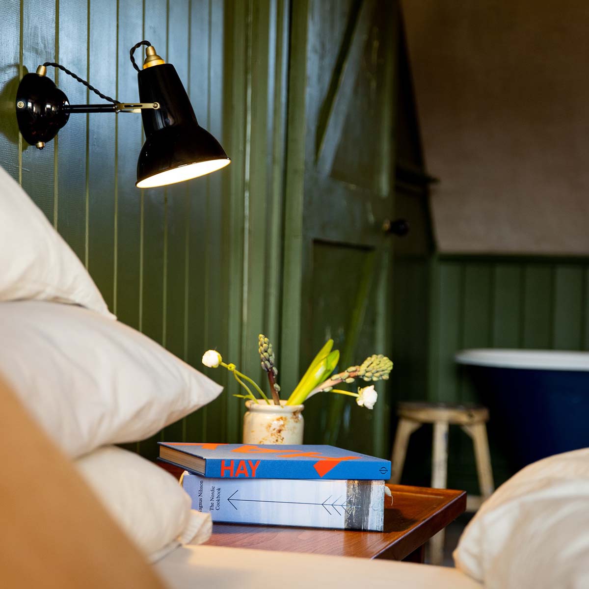 Anglepoise Original 1227 Wandleuchte, Ø: 13 cm, H: 16 cm im Wohnambiente: schwarze Wandleuchte im Schlafzimmer mit dunkelblauer Wand, Trockenblumen und minimalistischer Einrichtung.