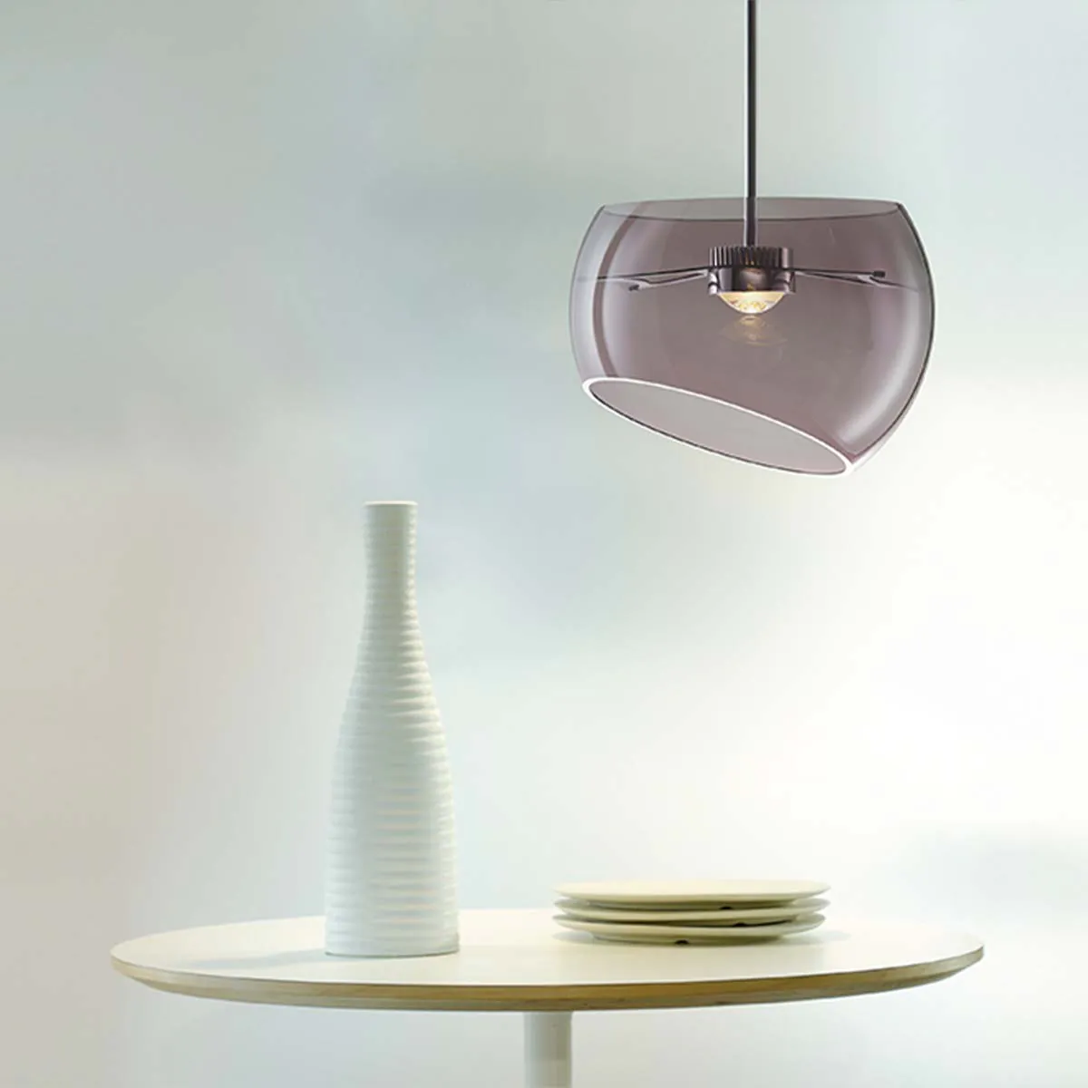 Halbkugelförmige Pendelleuchte über einem Tisch hängend