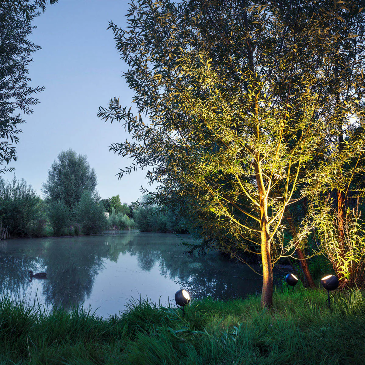 Runde Bodenleuchte für außen mit connect Stecker in der Natur neben einem See