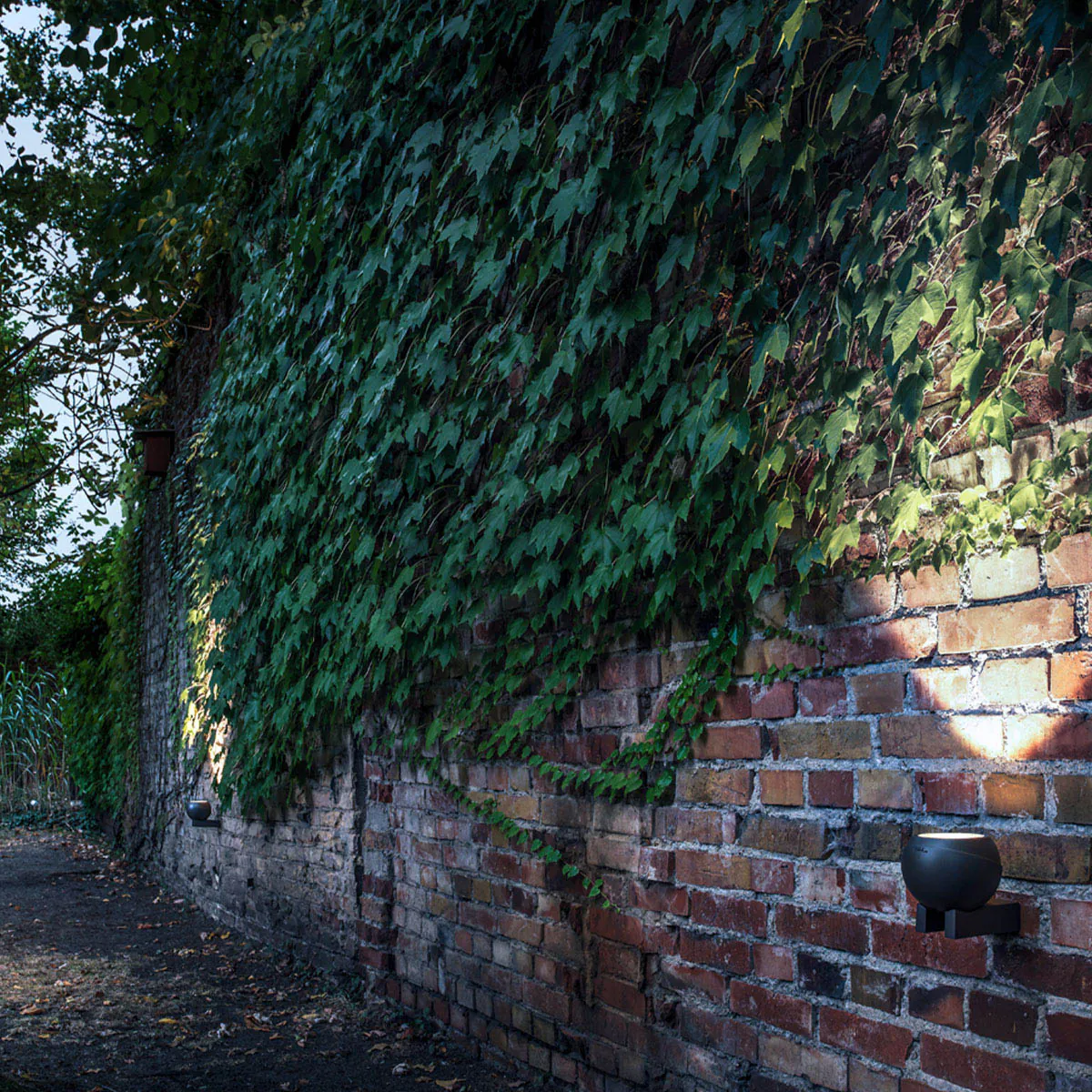 Runde Bodenleuchte für außen mit Schuko Stecker an der Mauer montiert
