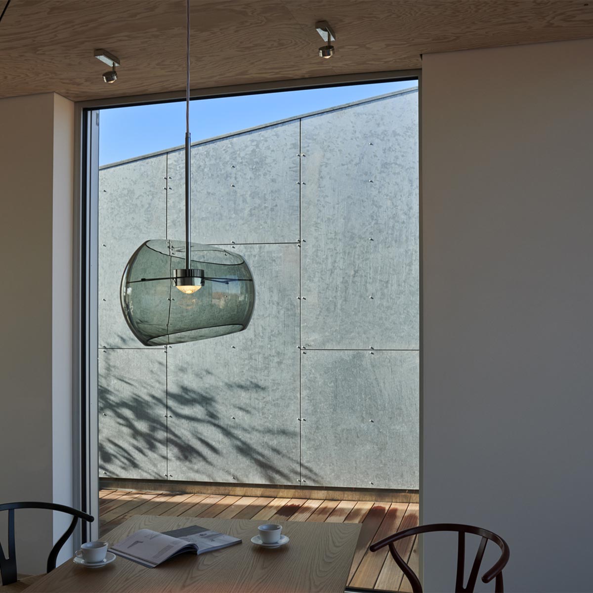 Halbkugelförmige Pendelleuchte über einem Tisch hängend