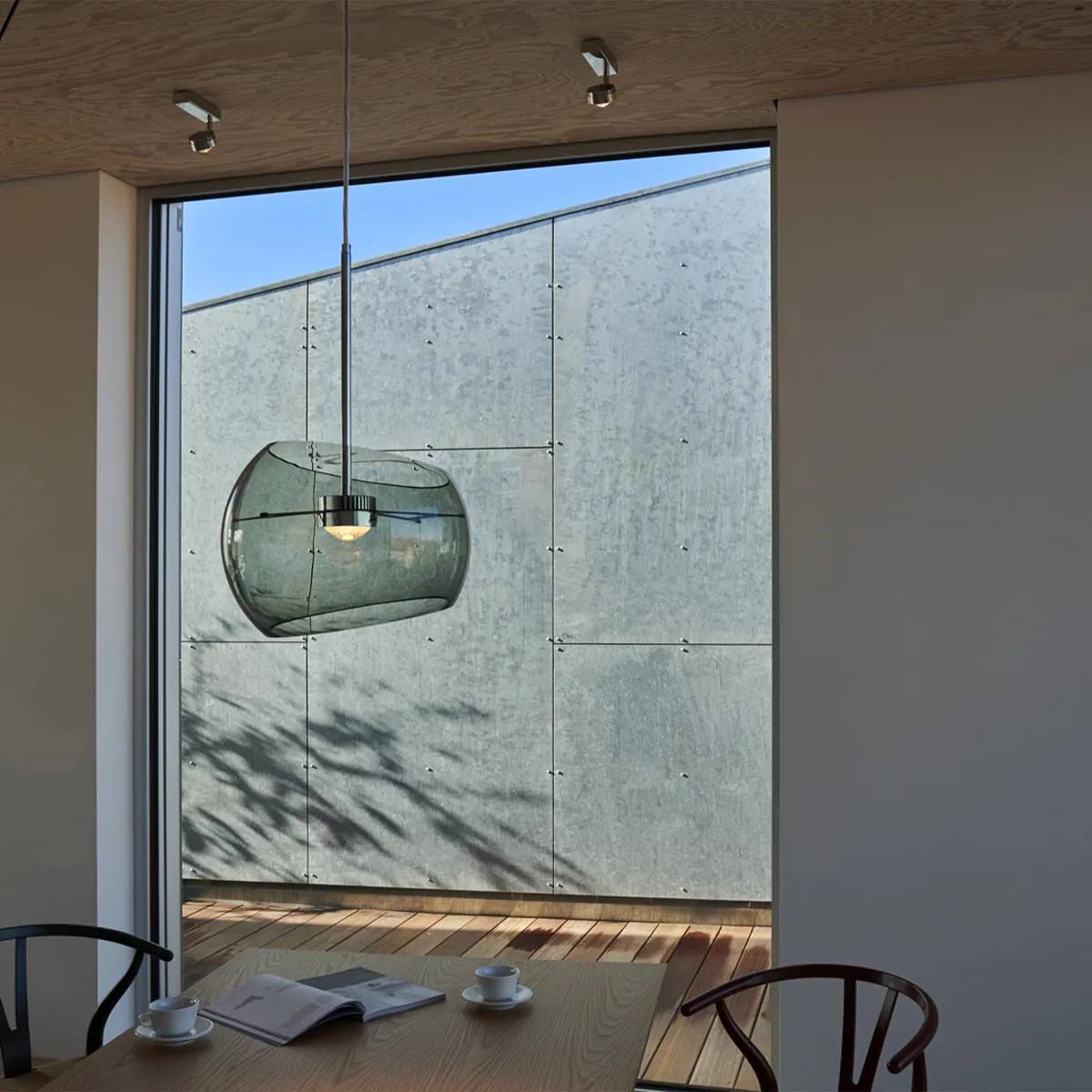 Halbkugelförmige Pendelleuchte über einem Tisch hängend