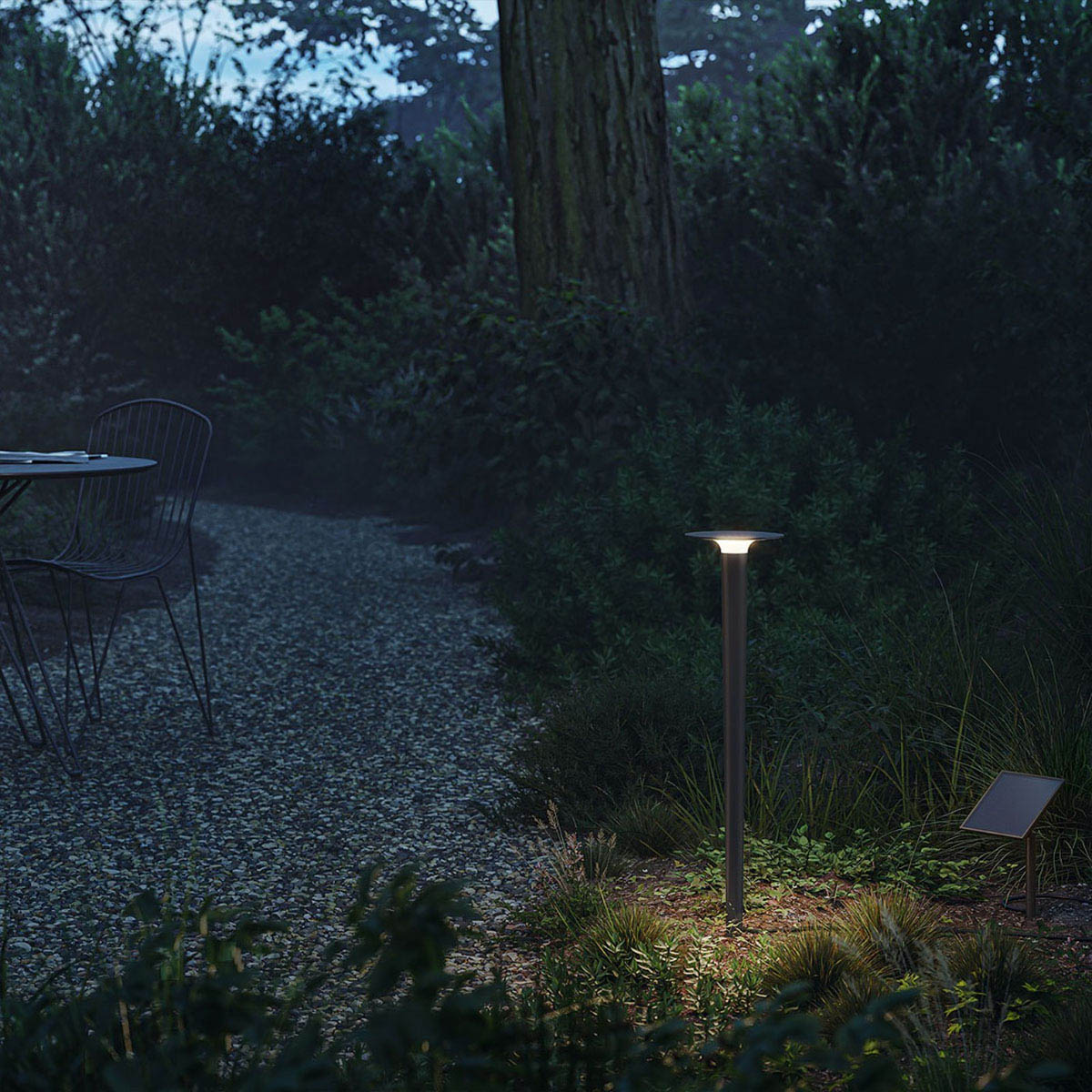 lix spike solar Erdspießleuchte, H: 85 cm, Deep Black Längliche Erdspießleuchte anthrazit mit Solarpanel und schwarzem Verbindungskabel  im Garten zwischen Pflanzen neben einem Weg