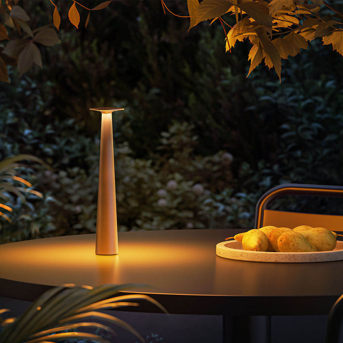 Schmale Akku Tischleuchte für außen bronze auf einem Tisch im Garten