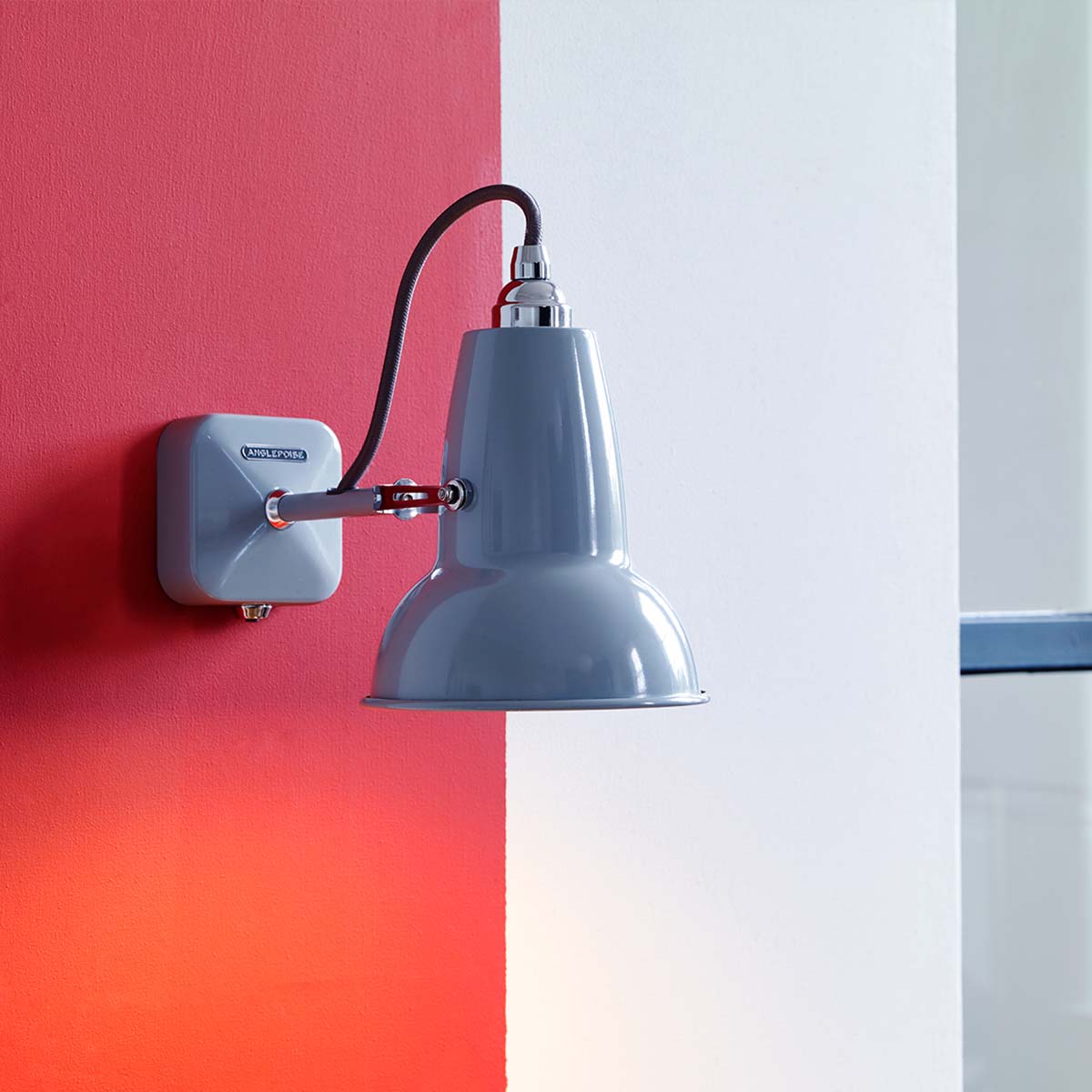 Anglepoise Original 1227 Mini Wandleuchte, Ø: 13 cm, H: 14 cm, Ceramic im Wohnambiente: graue Design-Wandleuchte an zweifarbiger Wand mit glänzender Oberfläche und charakteristischem Kabelbogen.