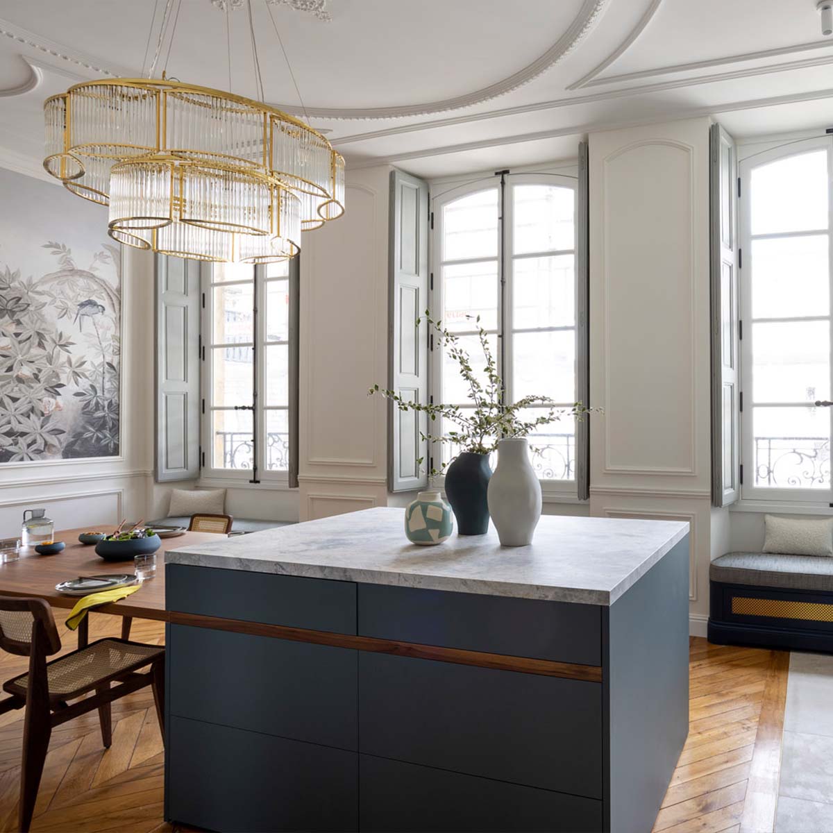 Moderner Kronleuchter mit geschwungenem Glasschirm über einen Esstisch hängend