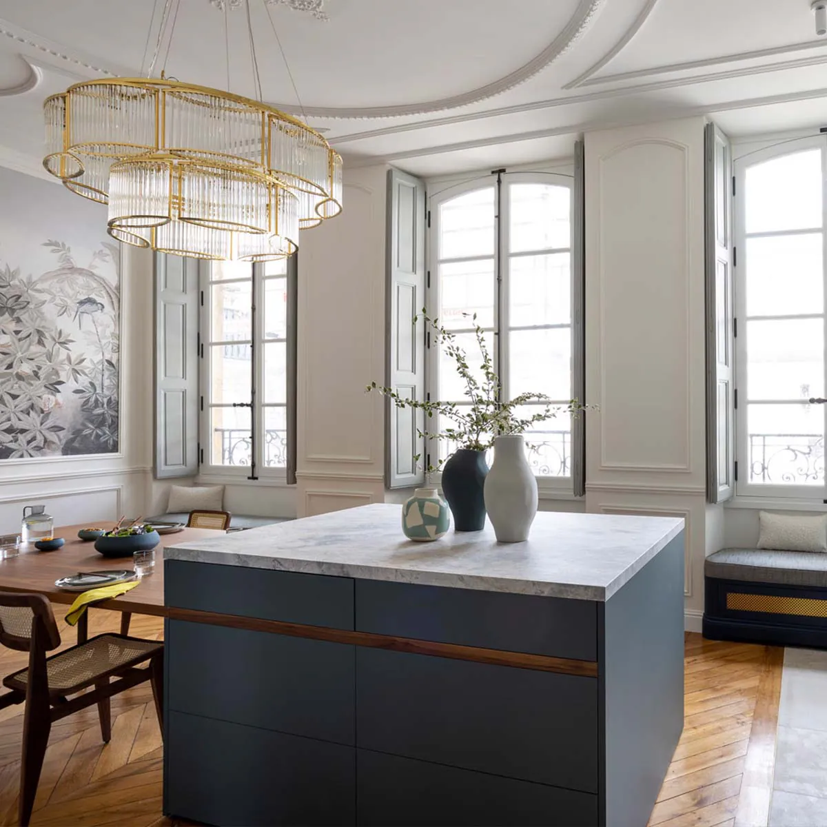 Moderner Kronleuchter mit geschwungenem Glasschirm über einen Esstisch hängend