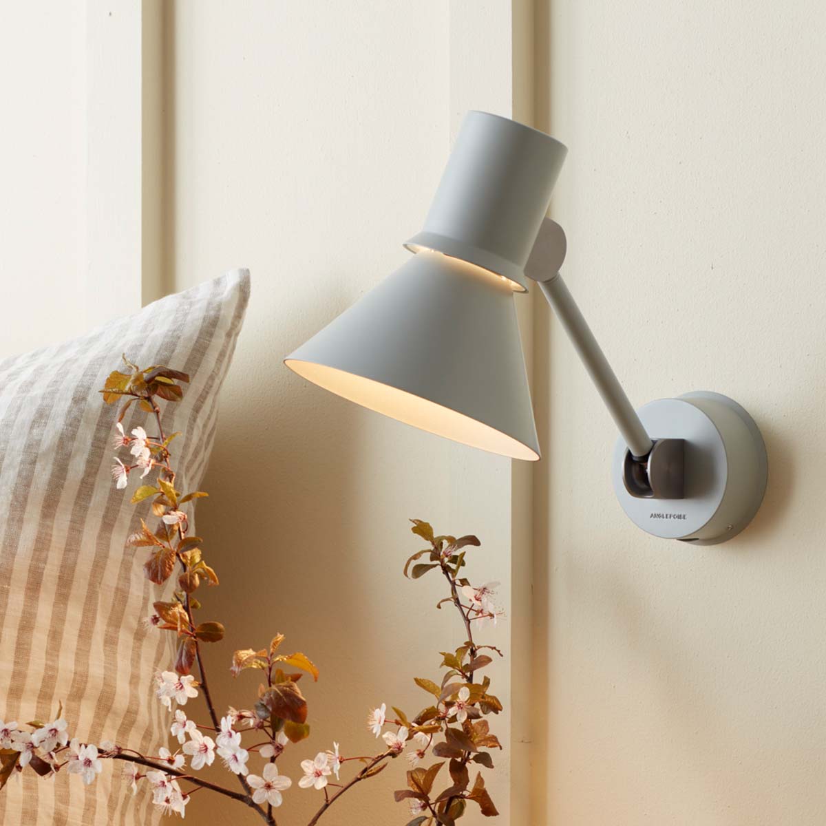 Anglepoise Type 80 W2 Wandleuchte, Ø: 14,5 cm, H: 16 cm im Wohnambiente: graue Wandleuchte im Schlafzimmer mit weichem Licht, gestreiften Kissen und minimalistischer Einrichtung. Anglepoise Type 80 W2 Wandleuchte, Ø: 14,5 cm, H: 16 cm im Wohnambiente: graue Wandleuchte im Schlafzimmer mit weichem Licht, gestreiften Kissen und minimalistischer Einrichtung.