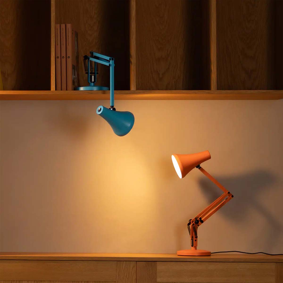 Farbige Design-Tischleuchten in Blau und Orange auf Holzregal mit indirekter Beleuchtung, perfekt für modernes Wohnen und stilvolle Akzente