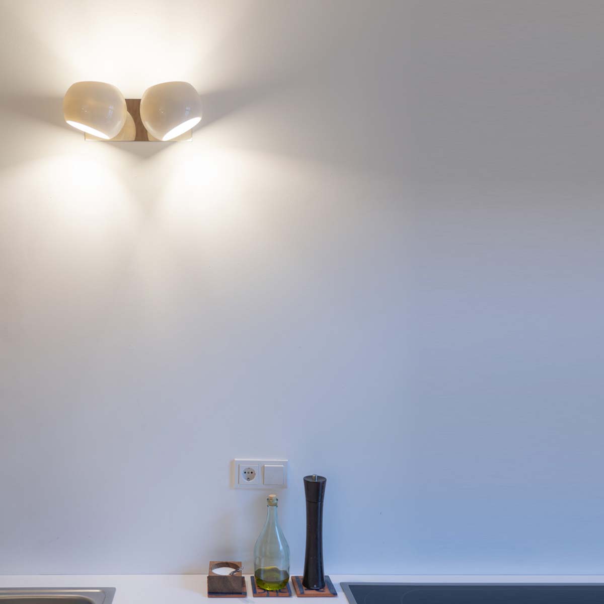 Licht im Raum White Moons 2 Doppelte Wandleuchte mit zwei weißen, asymmetrischen Lampenschirmen an der Wand in der Küche hängend Licht im Raum White Moons 2 Doppelte Wandleuchte mit zwei weißen, asymmetrischen Lampenschirmen an der Wand in der Küche hängend