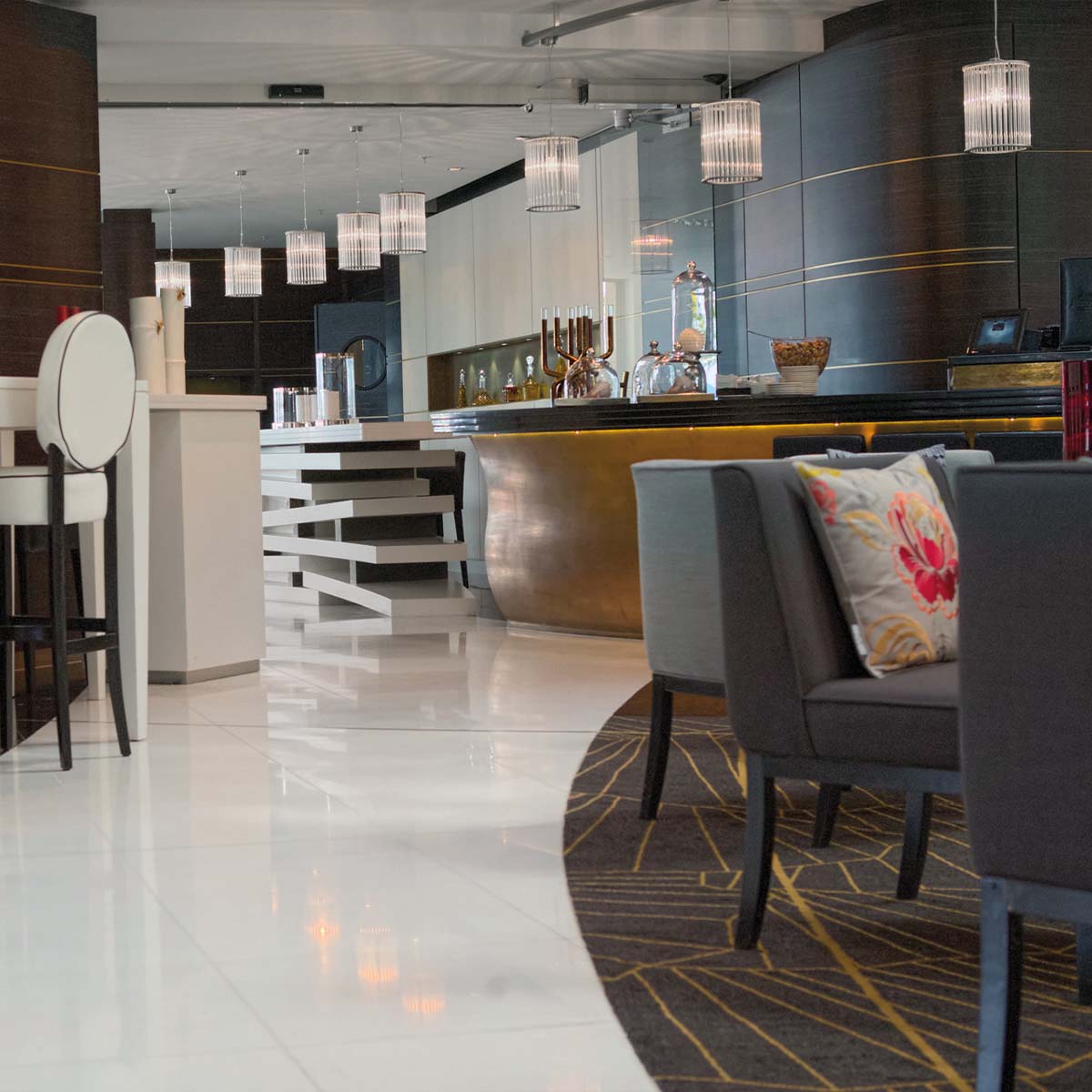Licht im Raum Stilio Uno 180 Mehrere elegante Pendelleuchten mit zylindrischen Glasschirmen in der Bar hängend