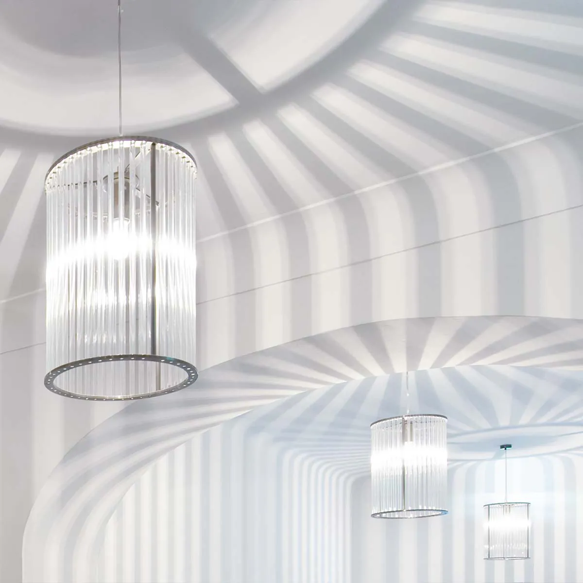 Mehrere elegante Pendelleuchten mit zylindrischem Glasschirm