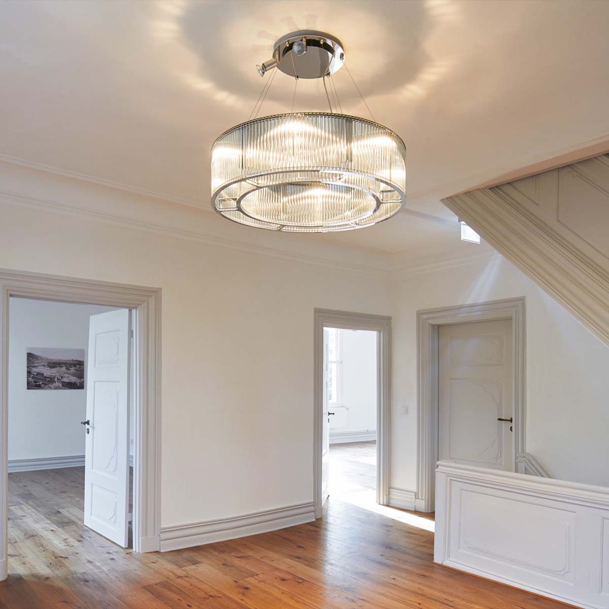 Elegante Pendelleuchte mit zylindrischen Glasschirm im Flur hängend